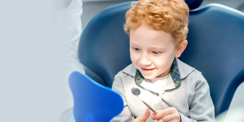 kid sitting in chair at smile design dental
